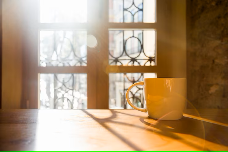 coffee cup on table sun shining through window