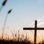 wooden cross in field Christian symbol